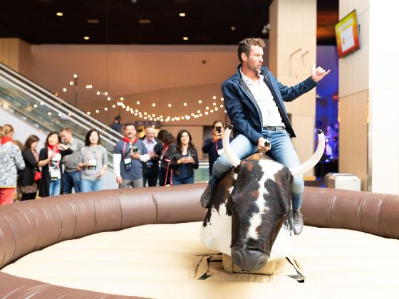 Man bull riding at a corporate event in the United Club Lounge spotlight 560x420